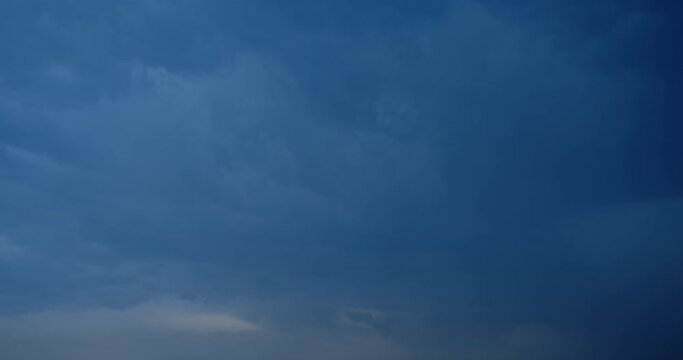 The movement of thunderclouds and a flash of lightning. Thunderstorm and bad weather are approaching.