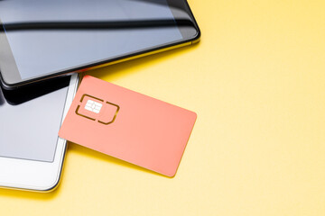 sim card for mobile phone near smartphone on yellow background. LTE sim card for cell phone