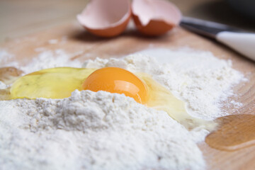 Fresh raw chicken eggs in flour close-up. Mix broken raw eggs and wheat flour, homemade cookies