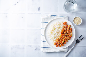 Sweet and sour chili sauce chicken with rice in a plate