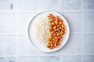 Sweet and sour chili sauce chicken with rice in a plate