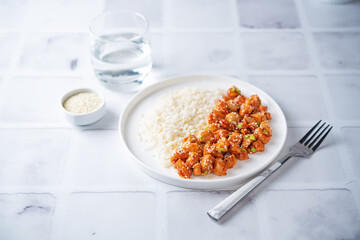 Sweet and sour chili sauce chicken with rice in a plate