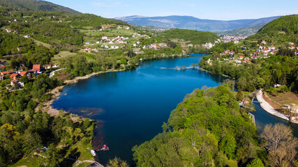 Fototapeta na wymiar Aerial drone view of lake, villages and forest in early spring. Plivsko jezero, Jajce, Bosnia and Herzegovina. 