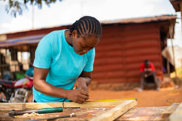 close up of a professional carpenter taking measurement of wood she wants to work on