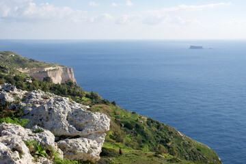 DINGLI CLIFFS, MALTA - JAN 02nd, 2020: Sea coast of Malta with Dingli Cliffs and Fifla Island in the background. Scenic high rising cliffs with panoramic view