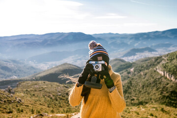 Young girl taking a picture on the Spanish mountains. Travel and lifestyle concept.