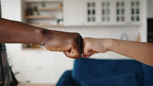 Unity of generations. Close up of african american parent and kid making fist bump gesture, expressing teamwork