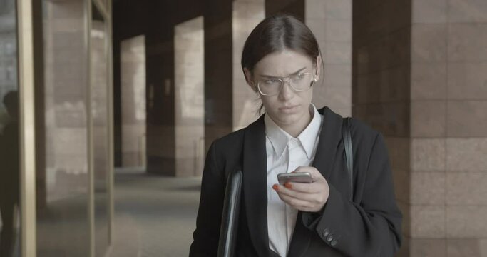 Confident upset businesswoman is reading the sms with bad news while walking. 4k.