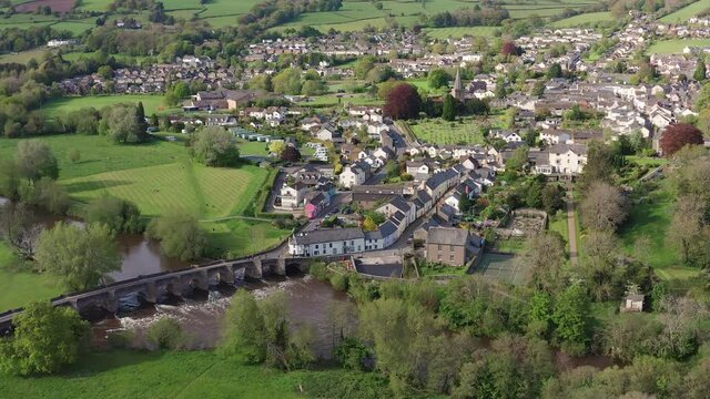 Aerial view of a fast flowing river and small, rural Welsh town