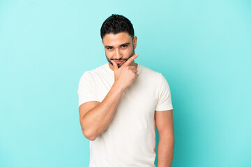 Young arab man isolated on blue background thinking