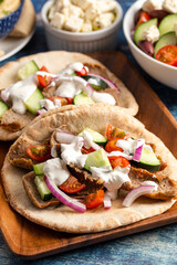 Gyros with Vegetables and White Garlic Sauce on a Rustic Wooden Table