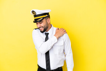 Airplane arab pilot man isolated on yellow background suffering from pain in shoulder for having made an effort © luismolinero