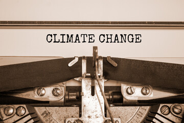 Climate change symbol. Words 'climate change' typed on retro typewriter. Beautiful white background, copy space. Sepia effect. Business, ecological and climate change concept. Copy space.