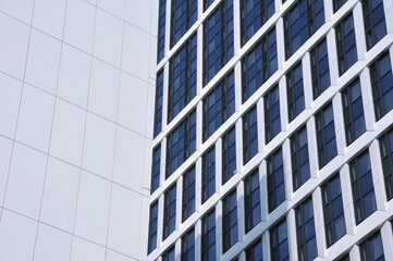 close up detail of tall high rose modern apartment buildings with white cladding and dark windows