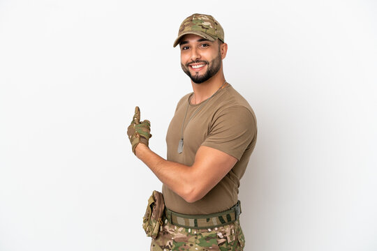 Young arab soldier man isolated on white background pointing back