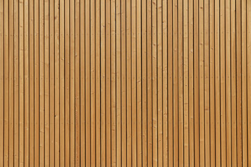 Fototapeta premium Facade sheathing made of wooden vertical planks. Warm yellow color.