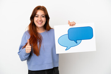 Young redhead woman isolated on white background holding a placard with speech bubble icon with thumb up