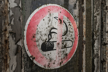 no smoking sign on a weathered door