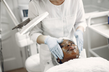 Girl doing facial procedures to beautician