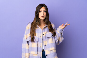 Teenager Brazilian girl over isolated purple background making doubts gesture