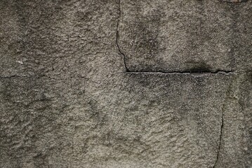 gray black stone texture with a crack on dirty concrete wall