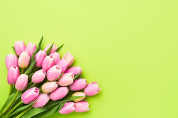 Pink tulips bouquet on a bright green background, selective focus. Mothers Day, birthday...