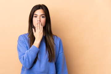 Teenager Brazilian girl over isolated background covering mouth with hand