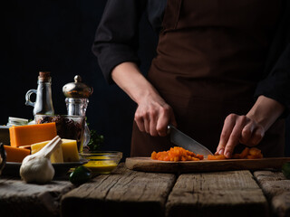 The cook prepares vegetable soup. The photo shows the process of cutting vegetables. There are also many ingredients in the frame. Contrast of colors. Still life.