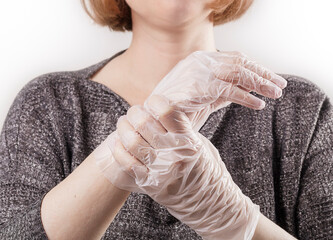 Woman wear silver casual blouse show hands in transparent disposable vinyl gloves. New normal...
