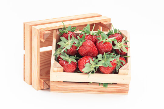 Strawberries in a wooden box on the white background.