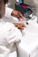 Close up image of mother helping her daughters to wash her hands
