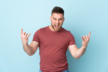 Naklejka premium Russian handsome man over isolated background making horn gesture