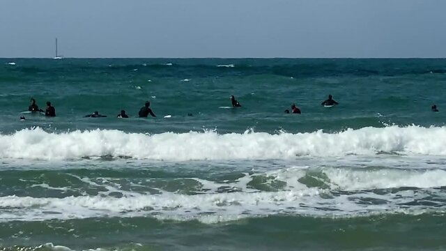 Serfers and serfing at Tel Baruch Mediterranean sea beach. Tel Aviv, Israel.  HD