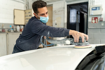 Man with electric sander works sanding high-end car. Madrid