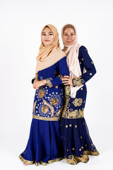 Fototapeta na wymiar Studio portrait of mother and daughter dressed for an event. Fashion for dinner, event and feast day. Studio shot with white background.
