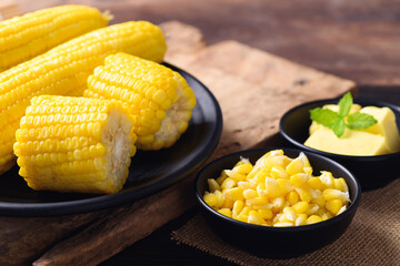 Sweet corn and butter in a bowl on wooden background