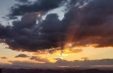 Raggi di sole trafiggono le nuvole al tramonto