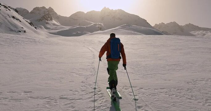 Lonely ski guide hiking to the top of the mountain. Ski touring in snowy white nature. No pressure just sports. A cold ski adventure with breathtaking views in Tirol. First ski track,skitouring vid 4K