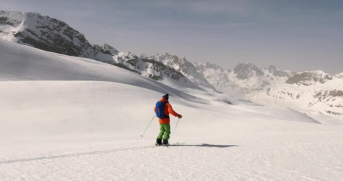 Absolute happiness after a ski tour, enjoying freeride skiing downhill. First ski tracks offpist with the best mountain view in Tirol backcountry. Ski mountain gudie freeride skiing in fresh snow.  4k