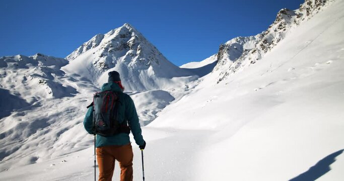 Ski touring in in beautiful mountain sceneries in tyrol. Backcountry skitour with friends. Hiking to the top of the mountain with ski touring gear. First track in fresh snow. 4k follow camera shooting