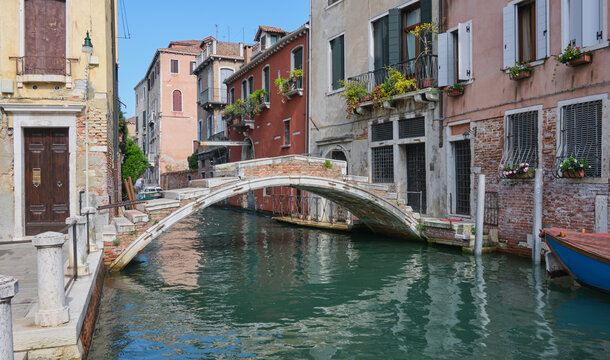 the ancient Chiodo bridge lays in the bright afternoon sun. The overpass is reflected in the canal beneath, this is the only remaining bridge without parapet