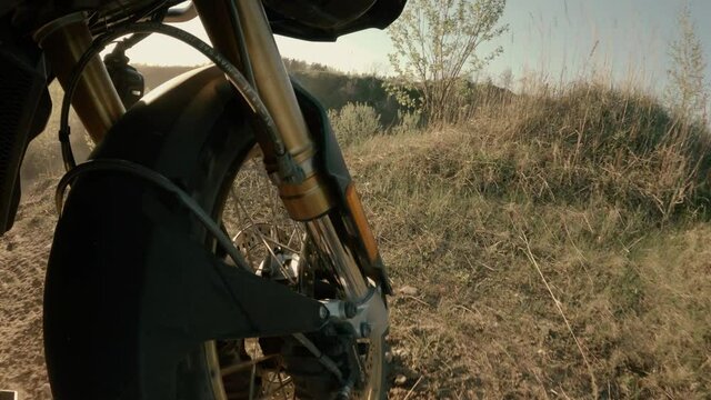 BMW GS motorcycle riding through dirty sand career. Low wide angle. Front wheel visible. Filmed with gopro 9.