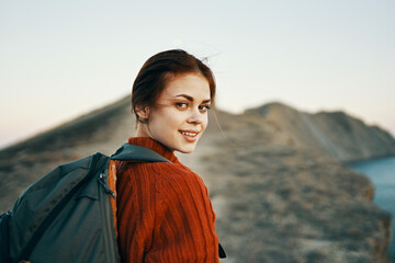 happy travel with backpack woman climbs to the top of the mountains along the path