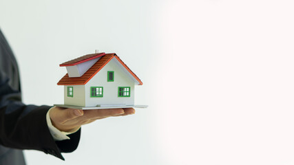 Fototapeta na wymiar Small house model in hand real estate agent white background