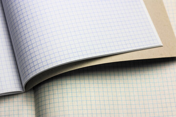 Opened notepad notebook with checkered sheets. Blank sheet in a cage. School.