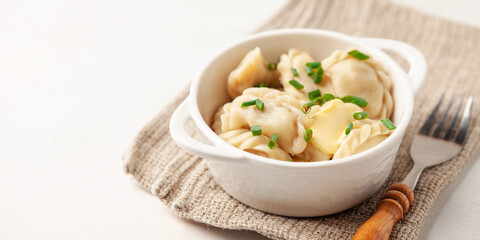 Appetizing homemade Russian dumplings pelmeni stuffed with meat mince with butter in a bowl on the table.