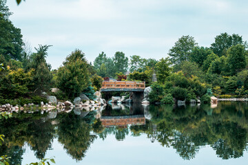 Fototapeta na wymiar The bridge at the japanese garden reflecting in the lake on a still day