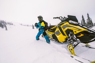  Rider on snowmobile  in beautiful winter landscape with forest and mountains