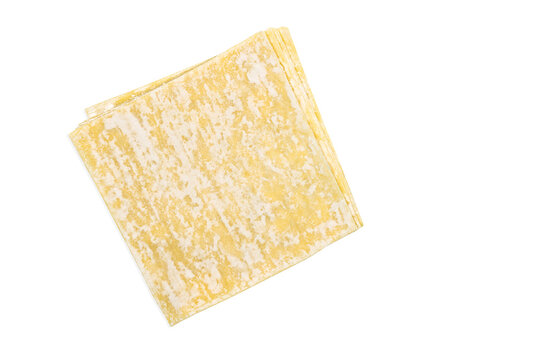 Top view stack of Wonton or Chinese dumpling sheets, image with clipping path, isolated yellow dumpling sheets on white background.
