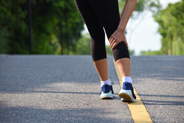 Fototapeta na wymiar Woman massaging sore calf muscles during running training outdoor from pain.